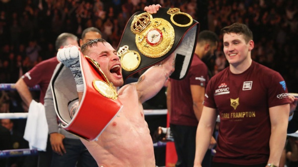 Carl Frampton celebrates with the WBA and IBF belts after his victory over Scott Quigg
